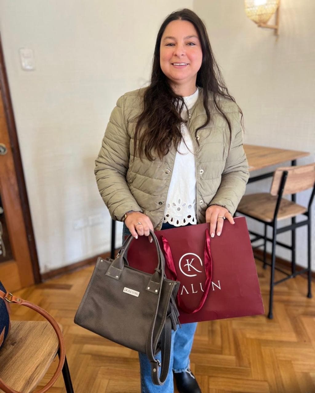 Clienta feliz con su cartera KALUN y la bolsa burdeo de la marca